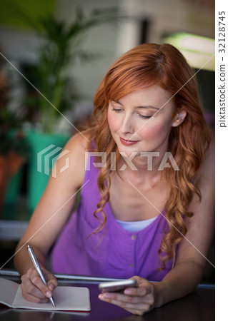 Female florist writing on notebook Female florist writing on notebook 32128745