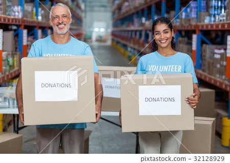 Portrait of two volunteers holding a donations box Portrait of two volunteers holding a donations box 32128929