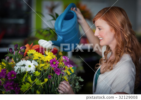 Female florist watering flowers Female florist watering flowers 32129008
