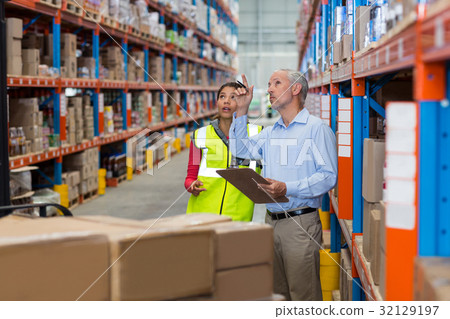 Warehouse manager and female worker interacting while checking inventory 32129197