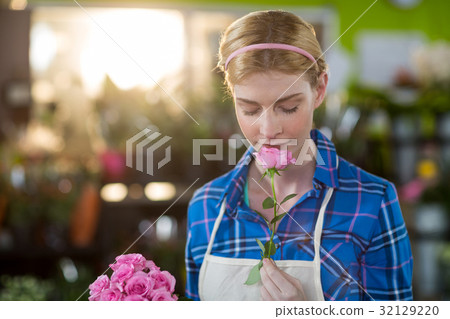 Female florist smelling pink rose 32129220