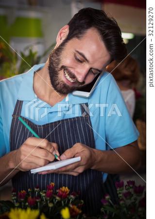 Male florist taking order on mobile phone 32129270
