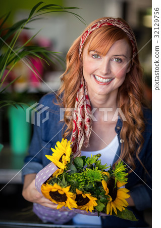Smiling female florist holding bunch of flower 32129756