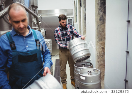 Manufacturer and worker carrying kegs 32129875