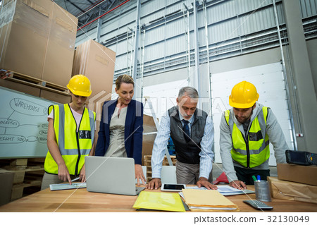 Warehouse workers and managers working in warehouse 32130049