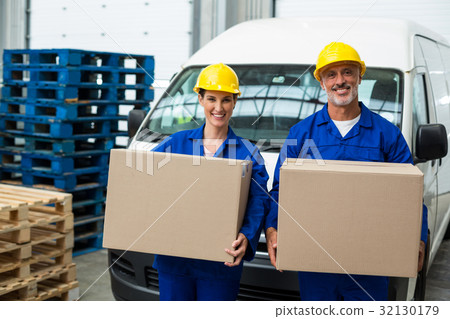 Portrait of delivery workers carrying cardboard box Portrait of delivery workers carrying cardboard box 32130179