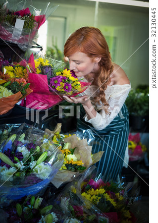 Female florist smelling flower bouquet 32130445