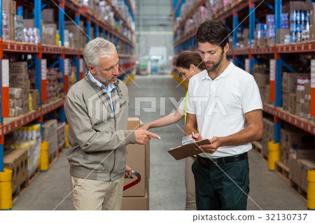 Warehouse manager and male worker interacting while working 32130737
