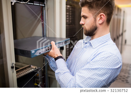 Technician removing server from rack mounted server 32130752
