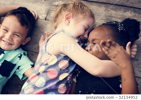 Diverse Little Kids Lay on the Wooden Floor Together Diverse Little Kids Lay on the Wooden Floor Together 32134952