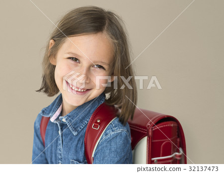 Young girl with a backpack cheerful studio portrait 32137473