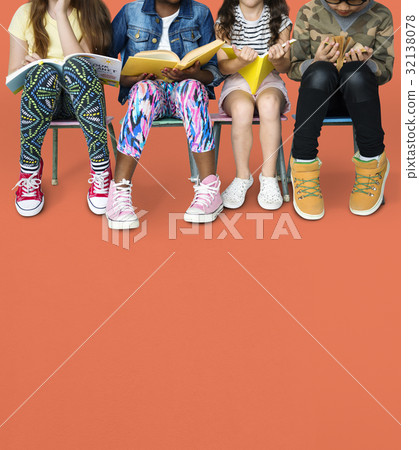 Diverse group of kids sitting in a row reading books Diverse group of kids sitting in a row reading books 32138078