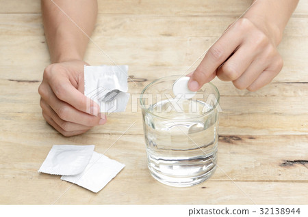 woman dropping effervescent tablet in glass woman dropping effervescent tablet in glass 32138944