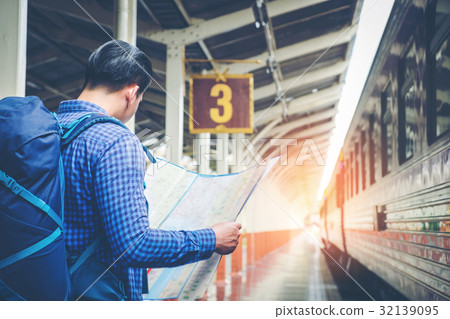 Traveler man with map and waits train on railway 32139095