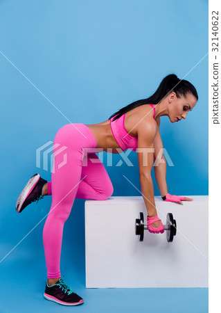 Muscular woman in pink leggings, top and gloves Muscular woman in pink leggings, top and gloves 32140622