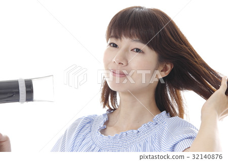 A woman touching her hair A woman touching her hair 32140876