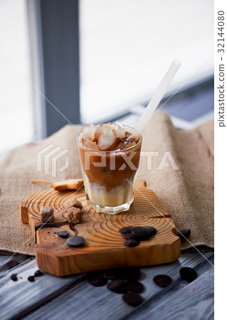 The Hong Kong iced coffee in a glass, with a straw The Hong Kong iced coffee in a glass, with a straw 32144080