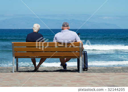 Senior couple waiting on a bench at sea 32144205