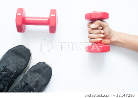 Creative flat lay of woman hand holding dumbbell Creative flat lay of woman hand holding dumbbell 32147286
