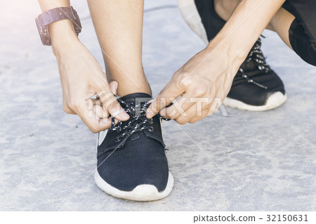 Female runner is tying her shoelace 32150631