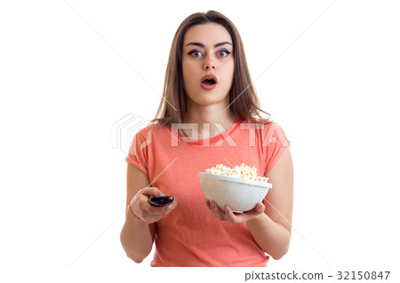 surprised young girl watching a tv with pop-corn surprised young girl watching a tv with pop-corn 32150847