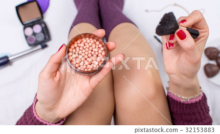 Girl applying blush balls in bed Girl applying blush balls in bed 32153883