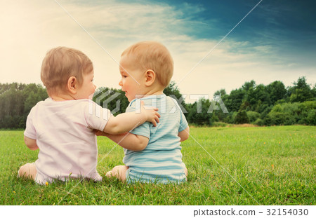 Babygirl and babyboy sitting in the grass Babygirl and babyboy sitting in the grass 32154030