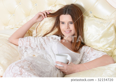 young woman lying on bed  32154720