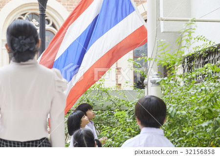 A teacher and her two pupils are standing and looking at national flag. A teacher and her two pupils are standing and looking at national flag. 32156858