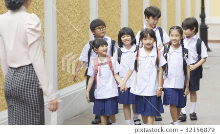 a group of pupils is walking towards the teacher 32156879