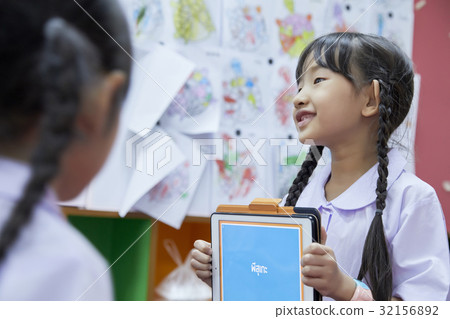 the pupil is showing a picture and smiling 32156892