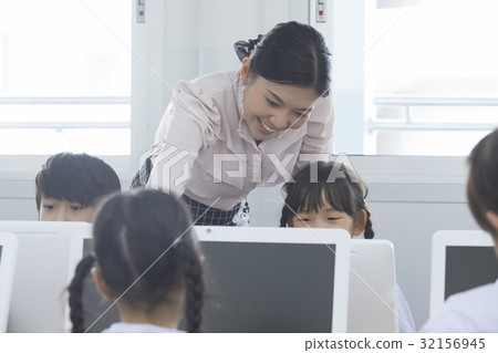 Teacher is teaching her students in the computer lesson Teacher is teaching her students in the computer lesson 32156945