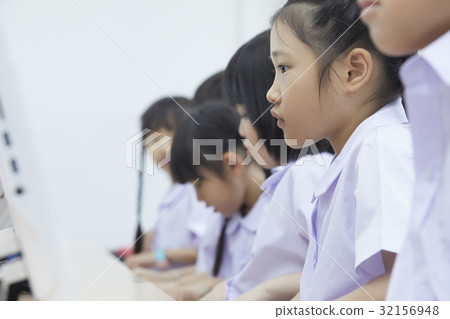 Schoolchildren are looking and practising skills in computer lesson. 32156948