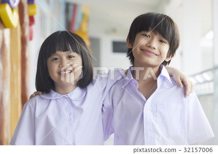 Two kids are smiling and putting arms on each other's shoulder. Two kids are smiling and putting arms on each other's shoulder. 32157006