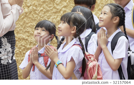 Thai pupils are smiling and greeting their teacher. 32157064