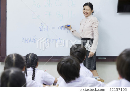 a photo of a teacher teaching English and smiling with her pupils. a photo of a teacher teaching English and smiling with her pupils. 32157103
