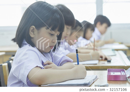 a photo of pupils focusing on writing something in classroom. a photo of pupils focusing on writing something in classroom. 32157106