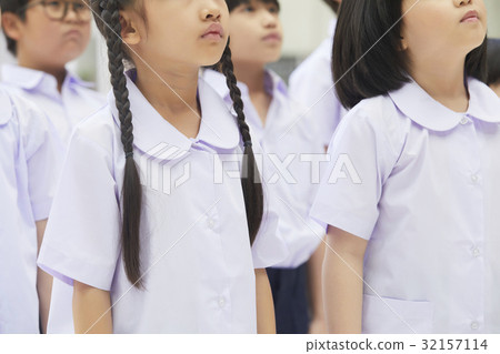 a group of students in uniform is standing together and looking up. 32157114