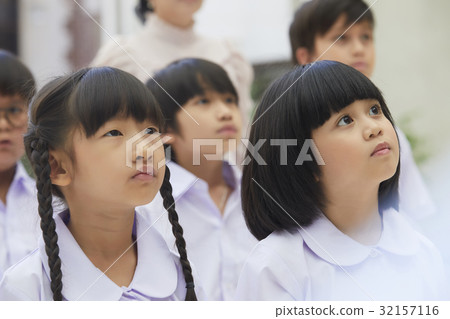 a photo of a group of students looking at something a photo of a group of students looking at something 32157116