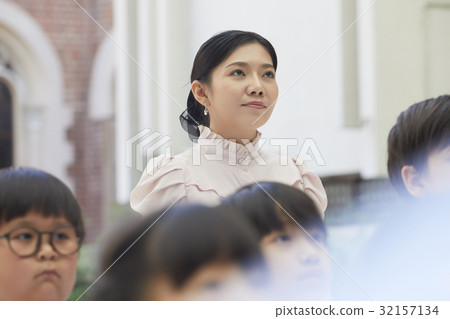 the teacher is standing outdoor and staring at something the teacher is standing outdoor and staring at something 32157134