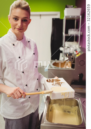 Portrait of worker filling chocolate mould 32162659