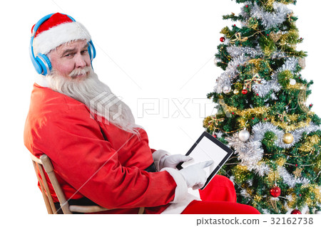 Santa claus using digital tablet with christmas tree Santa claus using digital tablet with christmas tree 32162738