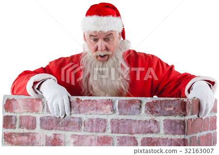 Santa claus peeking over the wall 32163007