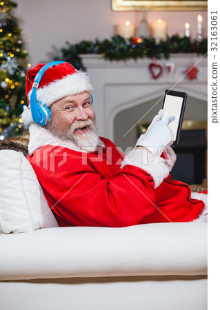 Santa claus using digital tablet at home Santa claus using digital tablet at home 32163061