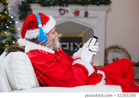 Santa claus using mobile phone at home Santa claus using mobile phone at home 32163260