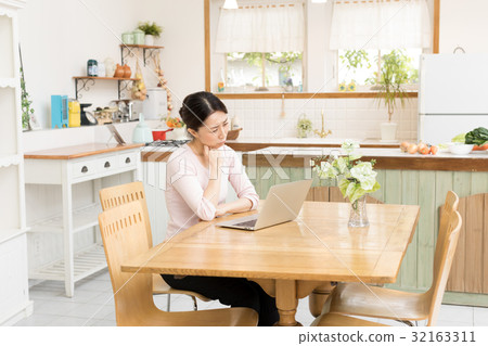 Housewife using a personal computer Housewife using a personal computer 32163311