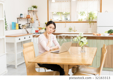 Housewife using a personal computer Housewife using a personal computer 32163313