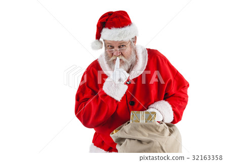 Santa claus with finger on lips and holding a gifts 32163358