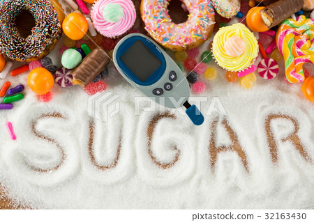 Various types of doughnuts and cupcakes with glucometer 32163430