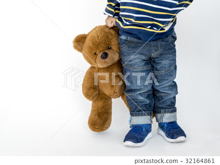 Young boy standing and holding teddy 32164861